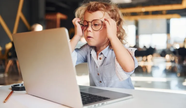 Child with vision impairment trying to see a computer screen, highlighting the need for accessible web design.